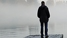 Ein Mann steht bei nebligem Wetter auf einem Steg  | Bild: picture-alliance/dpa