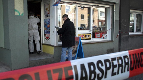 Polizisten untersuchen nach einem mutmaßlichen NSU-Mord in Dortmund den Tatort auf Spuren (Foto vom 04.04.2006). | Bild: picture alliance / dpa