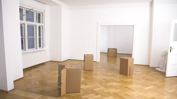 Eine leere, frisch geweißelte Wohnung mit Parkettboden, in der nur Pappkartons stehen | Bild: picture-alliance/dpa