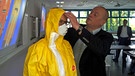 Eine Teilnehmerin legt sich Schutzkleidung an | Bild: BR-Mainfranken / Sascha Hack