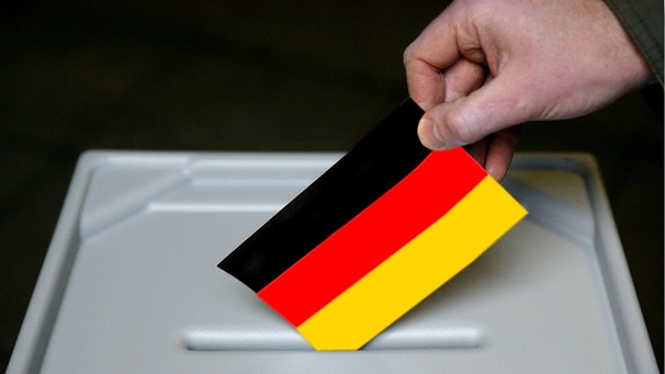 Eine hand steckt einen schwarz-rot-goldenen Stimmzettel in eine Wahlurne | Bild: pa/dpa/Ulrich Baumgarten