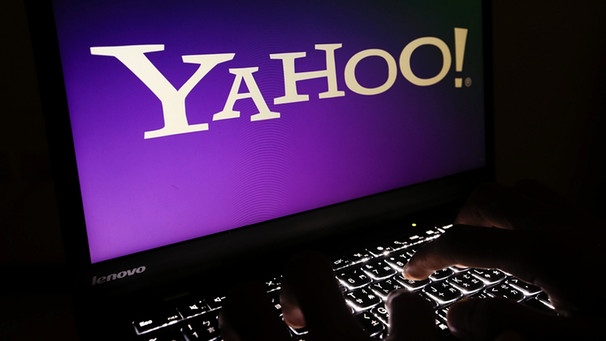 Finger tippen auf einem Laptop, dessen Bildschirm ein Yahoo-Logo anzeigt. | Bild: picture-alliance/dpa