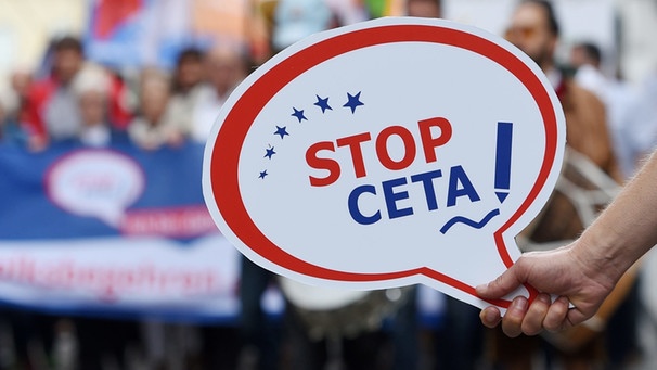 Symbolbild: Ein Demonstrant hält am 13.07.2016 in München ein Schild mit der Aufschrift "Stop Ceta". | Bild: picture-alliance/dpa