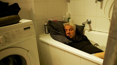 Hauptkommissar Franz Leitmayr (Udo Wachtveitl) findet in seiner verwüsteten Wohnung nur einen Schlafplatz in der Badewanne. | Bild: BR/Bernd Schuller