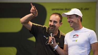 Von links: Edi van Beek (Bayern 3-Musikchef, Bayerischer Rundfunk) und Bernd-Uwe Gutknecht (Moderator, BR) beim Challenge Roth Triathlon. | Bild: BR/BR/Max Hofstetter