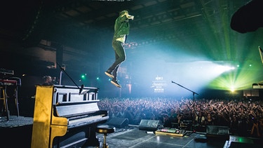Joris springt während eines Konzert auf der Bühne  | Bild: Joris / BR