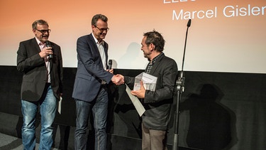 Thomas Sessner überreicht Marcel Gisler den Kino Kino Publikumspreis | Bild: BR/Kimmelzwinger