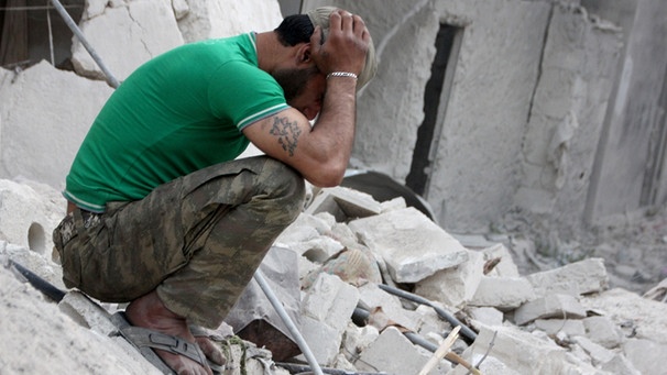 Ein Mann kniet in einem Trümmerfeld in Aleppo | Bild: picture-alliance/dpa