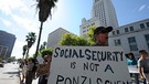 epa02949188 Charles Poper holds a sign that reads 'Social Security is not a Ponzi Scheme' as he joined hundreds of other demontrators in downtown Los Angeles, California, USA 03 October 2011. Hundreds of demonstrators are camping out in Los Angeles as part of a nationwide protest against tax breaks and other government policies towards banks and big corporations and as well as social entitlement programs that some politicians are calling to reforms. EPA/MIKE NELSON  +++(c) dpa - Bildfunk+++ | Bild: Mike Nelson