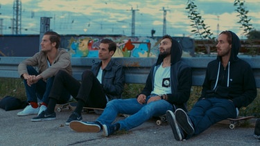 Vier Skateboarder sitzen auf der Straße und chillen  | Bild: Philipp Dettmer