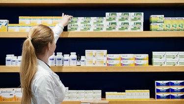 Apothekerin vor Regal mit Medikamenten | Bild:  BR/Julia Müller