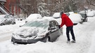 Zwei Menschen befreien ein Auto von sehr viel Schnee | Bild: picture-alliance/dpa