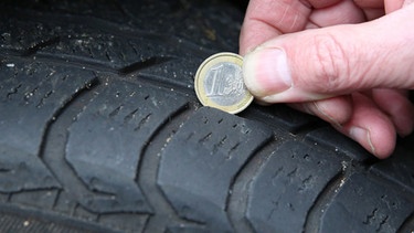 1-Euro-Münze hilft bei der Profiltiefemessung an Autoreifen | Bild: picture-alliance/dpa