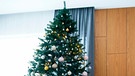 Großer Weihnachtsbaum ist nur mit Kugeln in Gold, Silber, Rosé und Blau geschmückt | Bild: mauritius images 