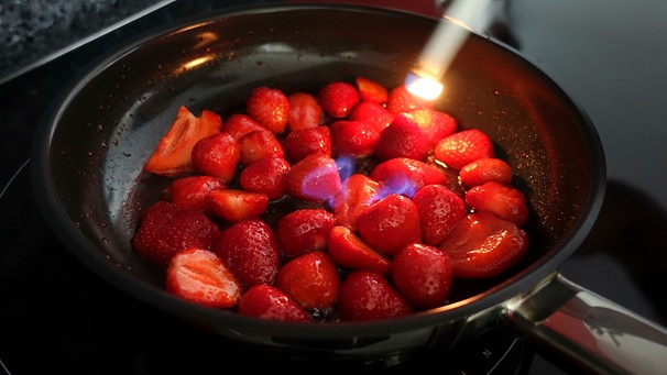 Erdbeeren in einer Pfanne, die flambiert werden | Bild: mauritius images / Katharina Hild