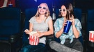 Zwei junge Damen essen Popcorn im Kino | Bild: mauritius-images