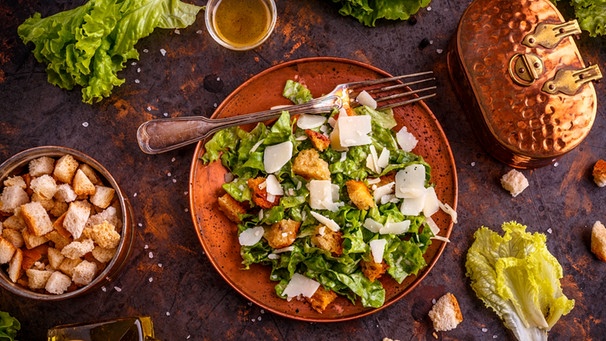 Ein klassischer Caesar Salad mit Parmesan und Brot auf einem Teller angerichtet. | Bild: mauritius images / Cseh Ioan / Alamy / Alamy Stock Photos