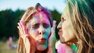 Zwei Frauen mit Farbe im Gesicht auf einem Holi-Fest | Bild: mauritius images / Image Source / Gpointstudio