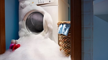 Eine Waschmaschine läuft aus und verteilt Schaum in einem Raum | Bild: mauritius images / DCPhoto / Alamy / Alamy Stock Photos