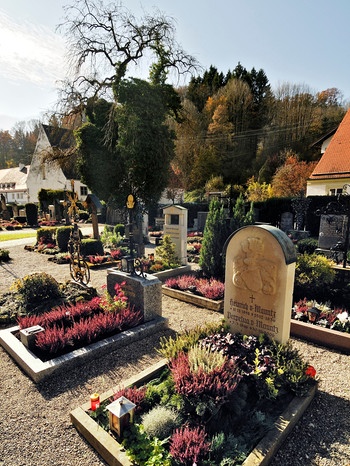 Bunt bepflanzte Gräber auf einem bayerischen Friedhof. | Bild: mauritius-images