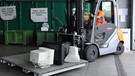 Rechner werden auf Recyclinghof mit Gabelstapler zu Container transportiert | Bild: picture-alliance/dpa