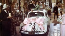 Hollywoods berühmteste Autos: Ken Berry und Helen Hayes fahren mit dem mit einer Schleife geschmückten VW Käfer Herbie im Film "Herbie groß in Fahrt" (1973) durch ein dekoriertes Haus | Bild: picture-alliance/dpa
