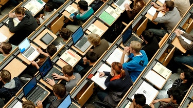 Studenten sitzen mit Laptop in einer Vorlesung | Bild: picture-alliance