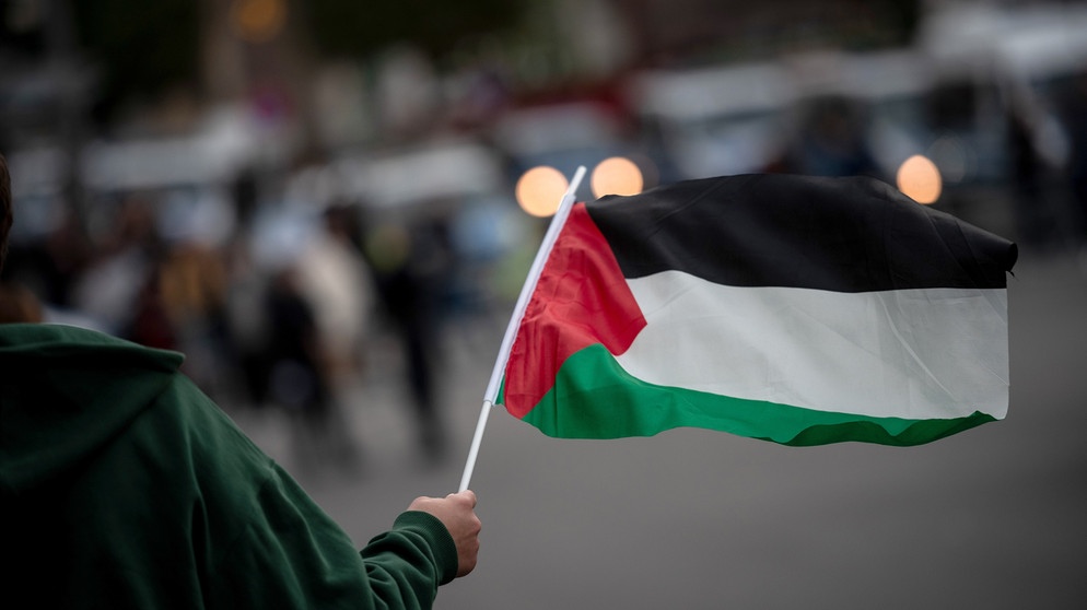 Eine Teilnehmerin einer pro-palästinensischen Demonstration hält eine palästinensische Fahne in der Hand. (Symbolbild) | Bild: picture alliance/dpa | Fabian Strauch