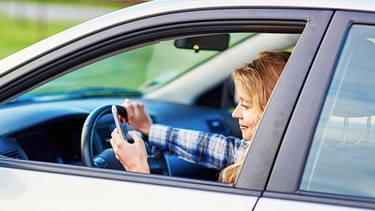 Frau schaut beim Fahren auf ihr Smartphone | Bild: colourbox.de