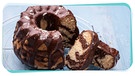 Auf einem Kuchengitter steht ein aufgeschnittener Marmorkuchen mit Schokoglasur | Bild: mauritius images / foodcollection / Kati Neudert - Montage: BR