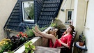 Frau sitz auf Ihrem Balkon in einem oberen Stockwerk | Bild: mauritius images  Westend61  Fl