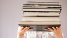 Eine Frau hält einen hohen Bücherstapel in den Händen
| Bild: BR/Johanna Schlüter