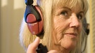 Eine Frau trägt Kopfhörer. Mithife eines Hörtests wird untersucht, wie gut ihr Hörvermögen ist. | Bild: picture-alliance/dpa