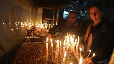Gläubige Christen zünden in der Geburtskirche in Bethlehem Kerzen an | Bild: picture alliance / AA