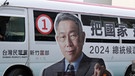 Ein Mann radelt an einem Bus mit dem Konterfei des Präsidentschaftskandidaten der Taiwanischen Volkspartei (TPP) Ko vorbei | Bild: dpa-Bildfunk/ChiangYing-ying