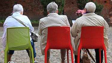 Ältere Besucher der Bundesgartenschau sitzen in Havelberg (Sachsen-Anhalt) während einer Pause auf Plastik-Stühlen | Bild: picture-alliance/dpa