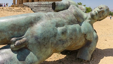 Antike griechische Statue eines nackten Mannes, die am Boden liegt. | Bild: picture-alliance/dpa