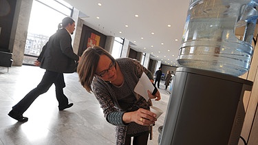 Frau holt sich Wasser aus Wasserspender | Bild: picture-alliance/dpa