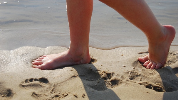 Schmerzfrei laufen mit gesunden Füßen - im Bild: barfuß Laufender im Sand | Bild: colourbox.com