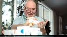 Mann bei der Einnahme von Tabletten mit zahlreichen Medikamentenschachtel auf dem Tisch | Bild: colourbox.com