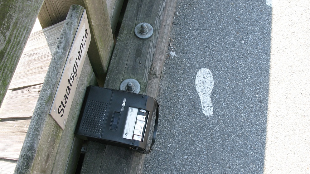 Schild "Staatsgrenze", Aufnahmegerät, aufgemalter Fußabdruck | Bild: Nikolai Vogel