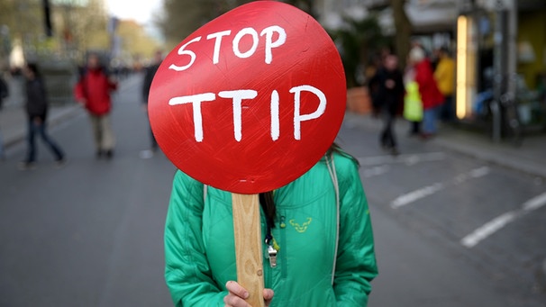 Eine Demonstrationsteilnehmerin mit Plakat nimmt in Hannover auf dem Opernplatz an einer Demonstration gegen das transatlantische Freihandelsabkommen TTIP teil.  | Bild: picture-alliance/dpa