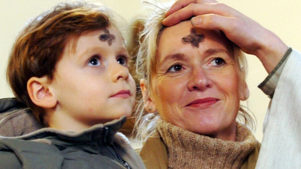 Pfarrer malt Gläubigen ein Aschekreuz auf die Stirn | Bild: picture-alliance/dpa