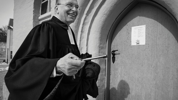 Pfarrer Lothar Wittkopf vor dem Portal der St. Laurentius Kirche, Rheinsberg, 2013 | Bild: Jendrik Bradaczek
