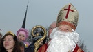 Der Nikolaus steht am 28.11.2010 während der Eröffnung des Weihnachtspostamtes in Himmelstadt (Unterfranken) neben einer Kinderschar.  | Bild: picture-alliance/dpa