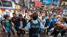 Ein Polizist weist am 31.08.2015 Asylsuchenden aus Syrien am Bahnhof in München den Weg zur Registrierungsstelle. | Bild: picture-alliance/dpa/Matthias Balk