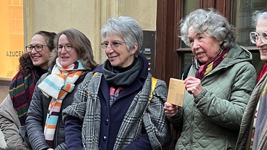 Die Silberleuchter von Olga Maier bringen die Familie zusammen. Ihre Nichte Miriam hält das Erinnerungszeichen für ihre in Treblinka ermordete Tante in Händen. | Bild: BR/Christine Hamel