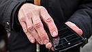 Symbolbild: Blinder hat Smartphone und Blindenstock in der Hand | Bild: picture-alliance/dpa