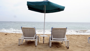 Zwei Liegestühle am Sandstrand | Bild: picture-alliance/dpa
