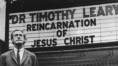 Der US-amerikanische "Drogenpapst" Timothy Leary steht vor einer Kinoreklame | Bild: picture-alliance/dpa